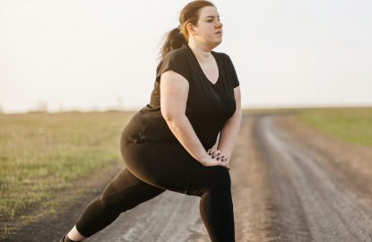 Girl stretching legs on dirt road