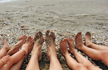 bare feet of a family on the shore of the Sea