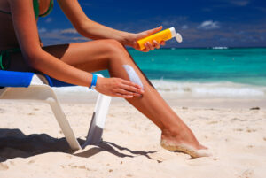 Tan woman applying sun protection lotion