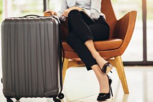 Business woman sitting in airport and waiting for her flight