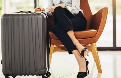 Business woman sitting in airport and waiting for her flight